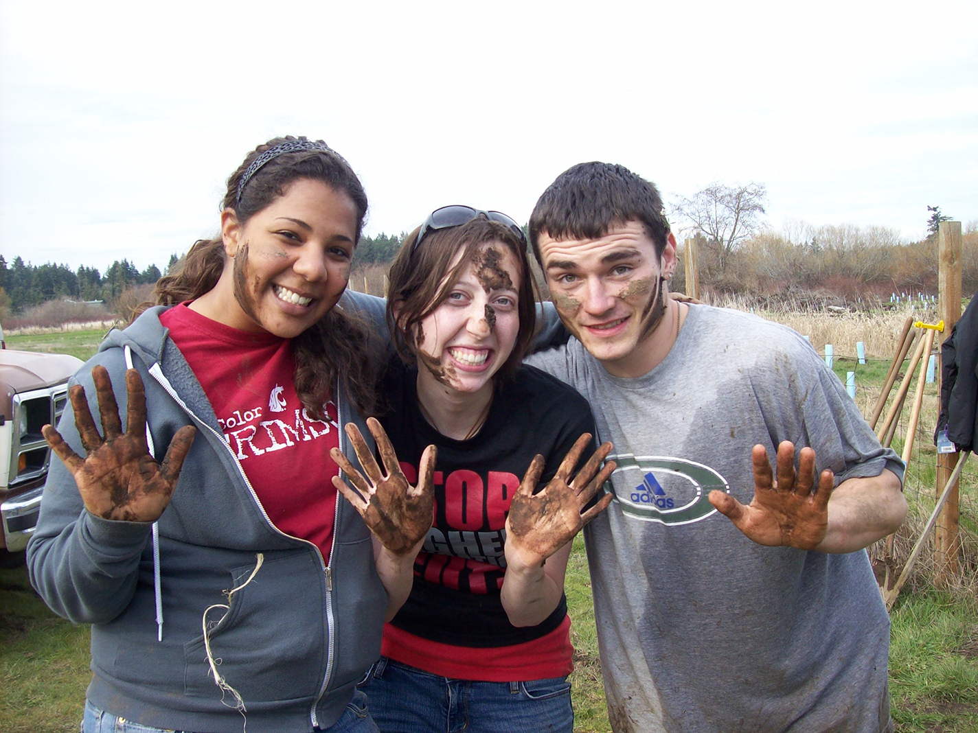 Three students posing for a photo after a hard day of work helping our community